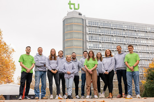 Das gesamte Hochschulsport-Team vor dem TU_Zeichen auf dem Mathe-Tower