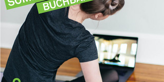Frau auf Yoga-Matte vor Laptop