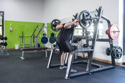 FFW-Trainer am Rack FFW-Trainer macht eine Kniebeuge mit gewichten am Rack