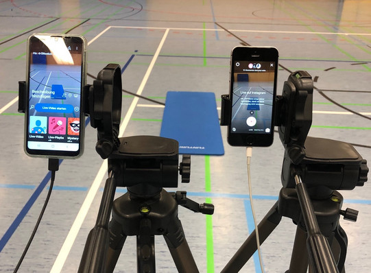 Zwei Streaming-Handys filmen eine Sport-Matte