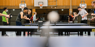 Mehrere Personen spielen Tischtennis im Tischtennis-Kurs