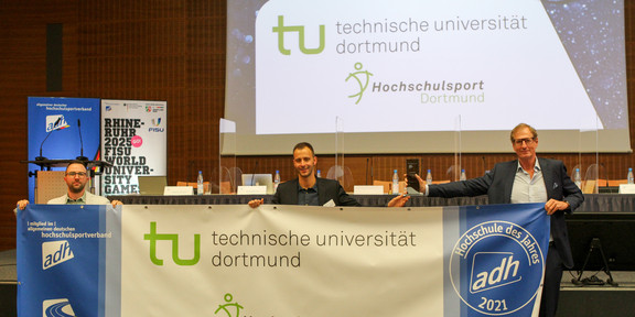 Christoph Edeler, Leiter des Hochschulsports und sein Stellvertreter Maximilian Roeren nehmen die Auszeichnung "Hochschule des Jahres" des adh entgegen