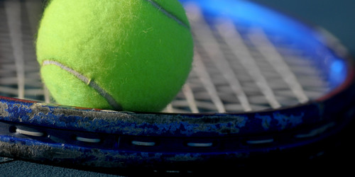 Tennisball liegt auf Tennisschläger 