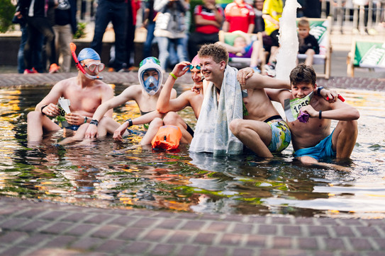 Campuslauf-Mannschaft im Strand-Kostüm im Brunnen auf dem Campus