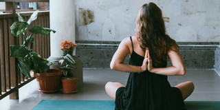 Frau zu Hause auf Yoga-Matte